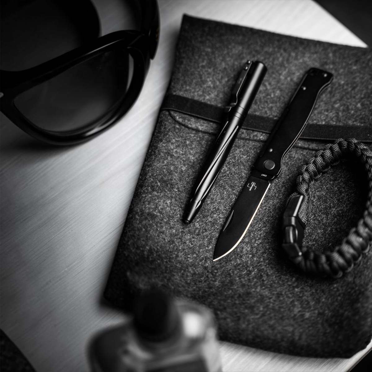 HUNTERLASE Böker Plus Atlas All Black Taschenmesser mit schwarzer Klinge und Edelstahlgriff auf einer Filzunterlage